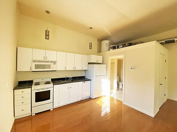 Brand new kitchen, bathroom and heat pump HVAC with spiral ductwork. Note the high ceilings and recessed lighting.