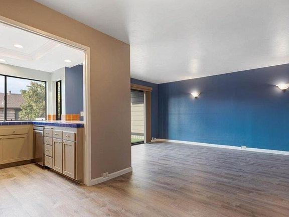 View from dining area to kitchen and living room. Paint updated to neutral color.