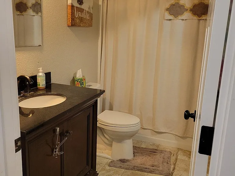 The bathroom is large and has a beautiful granite counter.