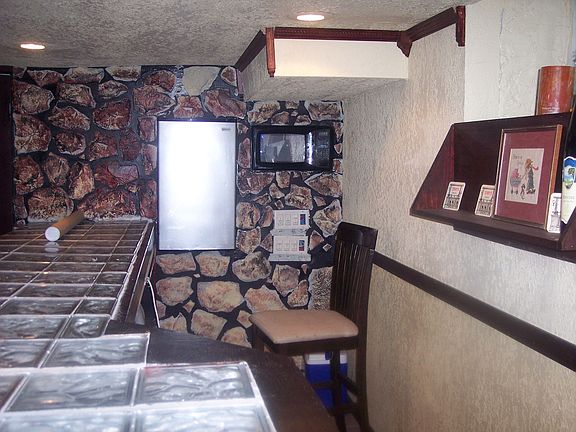 refrige and microwave inwall behind bar