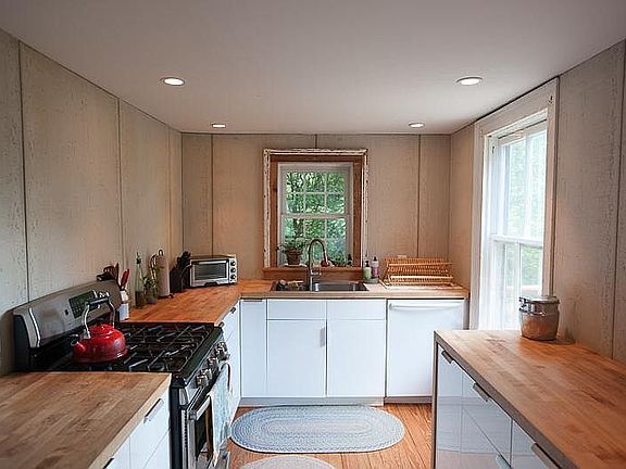 Renovated kitchen features modern appliances, gas range/oven