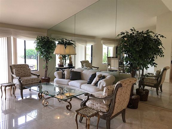 Vaulted ceilings, marble flooring, mirrors on walls - this room is light and bright with a view to the backyard