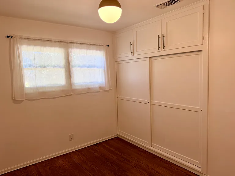 Back bedroom with lots of cabinets and closets.