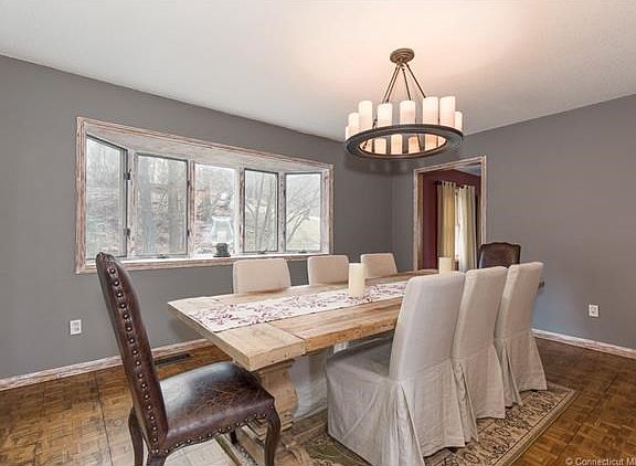 Beautiful formal dining room with bay window for wonderful lighting. Antique finishes are on the trim of the window, doorway and wall.
