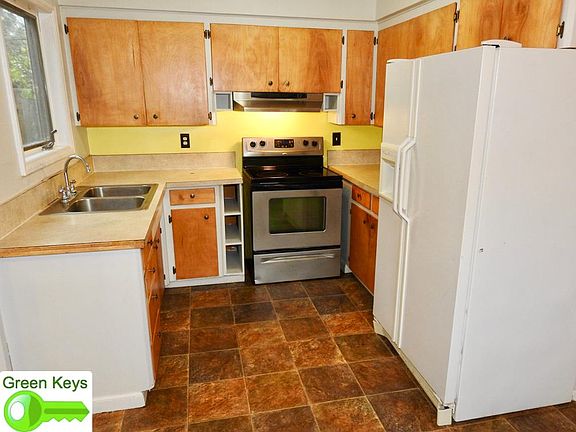Kitchen with stainless steel electric range and fan hood