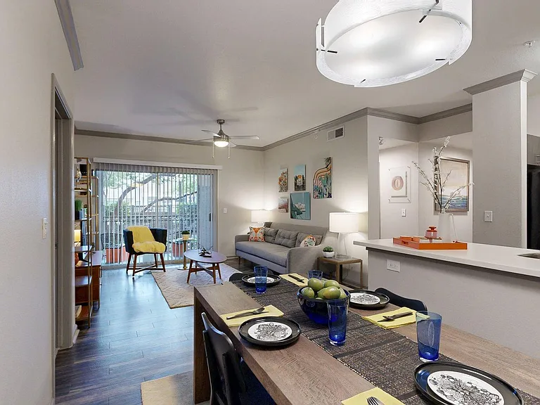 Apartment Kitchen with Stainless Steel Appliances, Dining and Living Room with Wood-Style Flooring and Patio/Balcony.