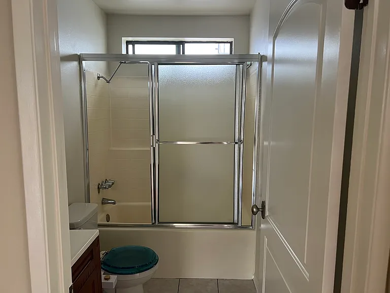 Off the kitchen bathroom with sink, shower, cabinets, and toilet