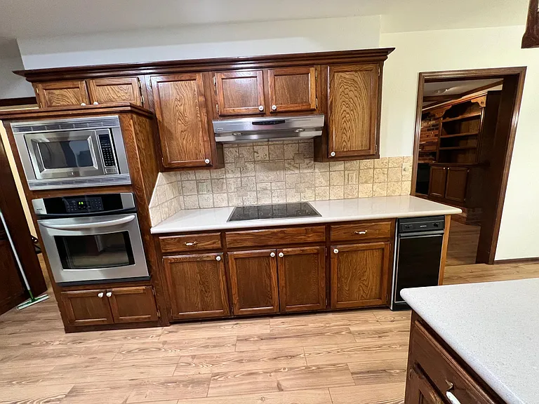 Kitchen with microwave, oven, trash compactor, fan with light over ceramic stove top. Lots of room in kitchen