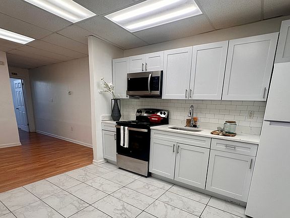 Fresh white kitchen with a brand-new stove and modern appliances.