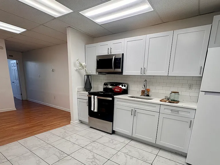 Fresh white kitchen with a brand-new stove and modern appliances.