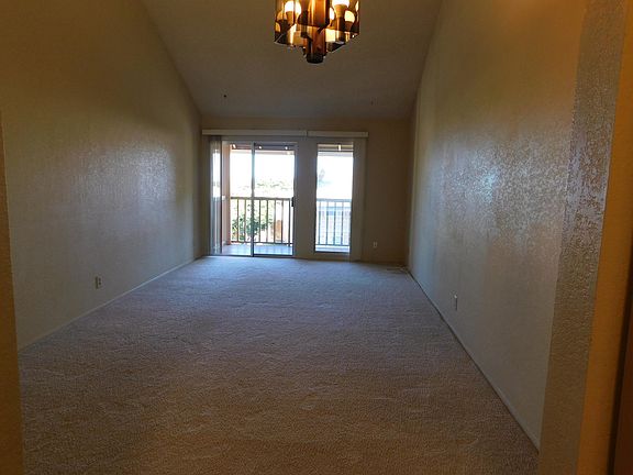 View from kitchen through dining/living to covered lanai with exterior storage closet.