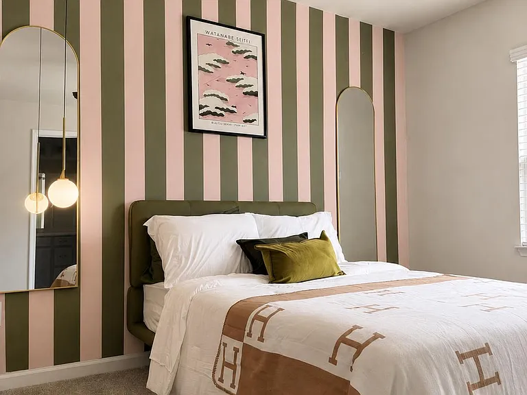 Bedroom features a full bed, ceiling fan, soft carpet, and window blinds, with convenient bedside lighting and mirrors.