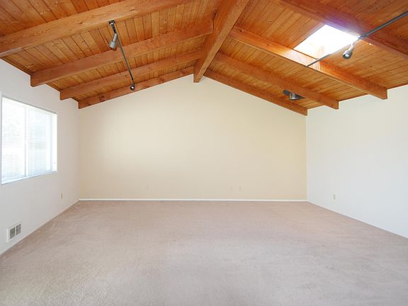 Large family room with open-beam cathedral ceiling and skylight.