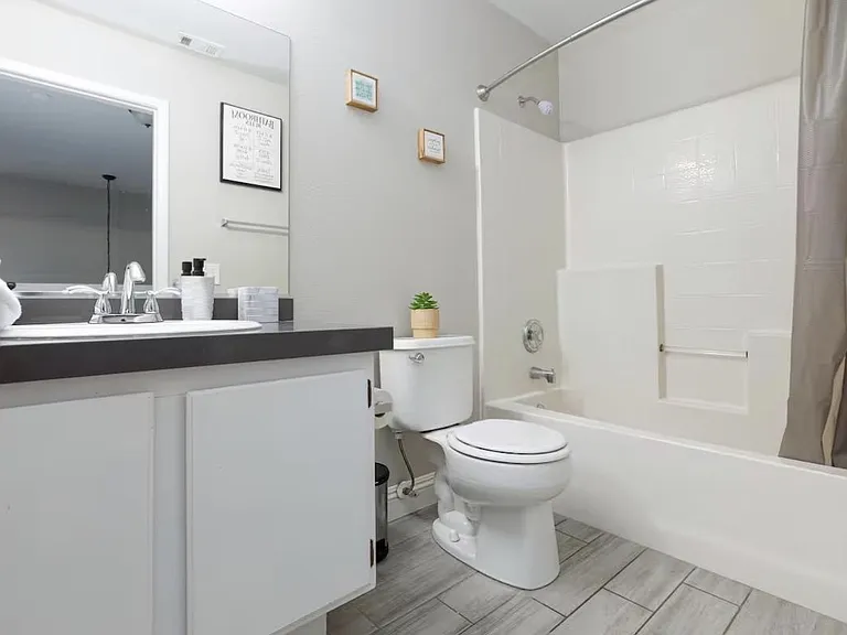 Full bath with single-sink vanity, large mirror, and tub/shower combo, plus ample counter space for daily essentials.