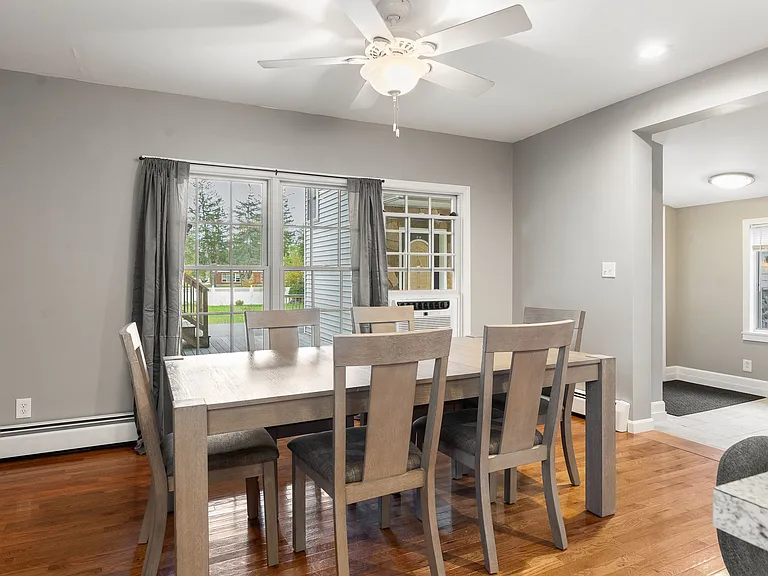 Dining Area, Hardwood Floors, Ceiling Fan, Large Windows, Open Floor Plan, Neutral Paint, Baseboard Heating.