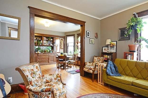 Spacious living room leading into classic dining room with gorgeous original wood trim and built-in cabinets