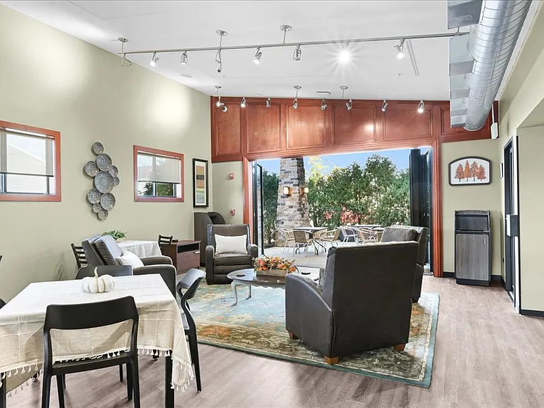 Community gathering room with games, cozy seating, and large dining table for a variety of engageing events.