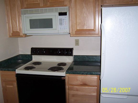 Kitchen includes electric smooth top range, microwave, and fridge.