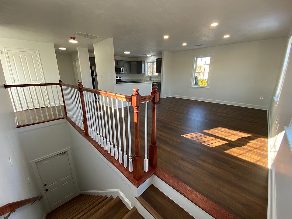 Staircase leading up to unit and open concept main living area with recessed lighting.
