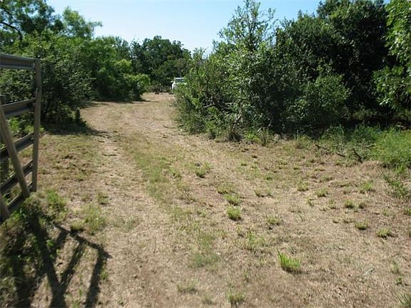 Entry gate open with driveway into property