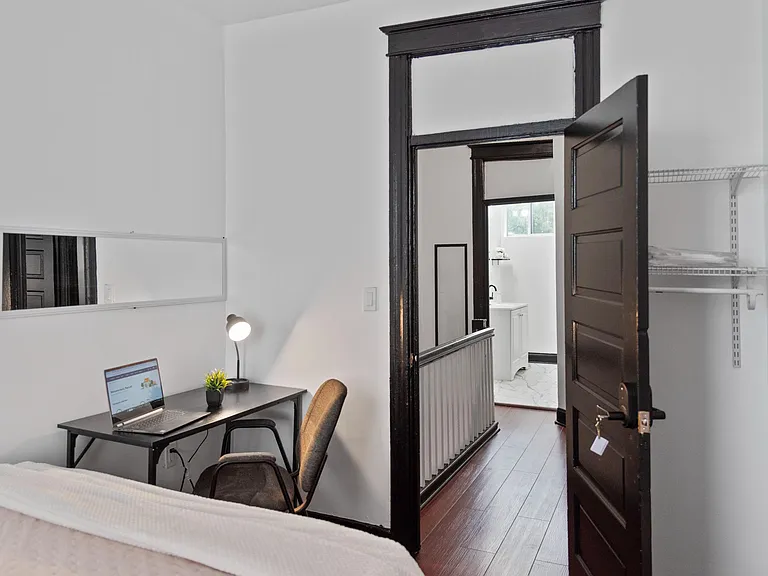 Private bedroom with a work desk and an organized closet system, plus convenient access to the hallway and nearby bath.