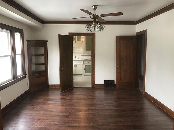Dining room with beautiful original hard wood floors and corner built in corner cabinets.