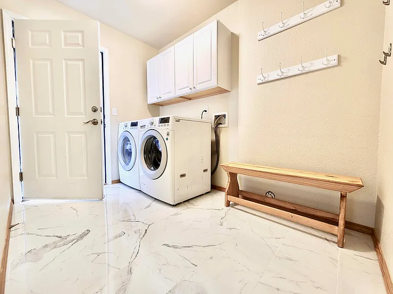 Laundry room, clean cupboards, and access to the garage. A nice bench for taking shoes on and off is included.