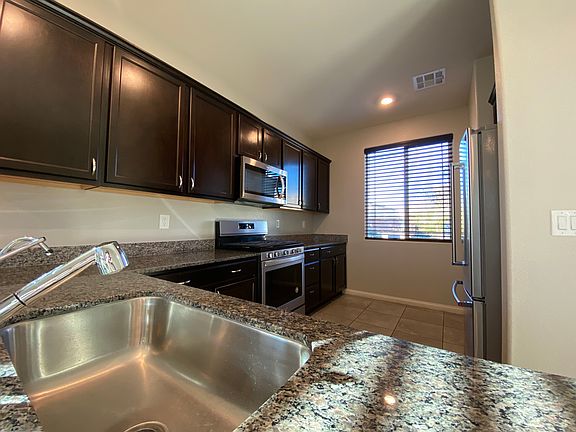 Kitchen has deep stainless steel sink, and appliances