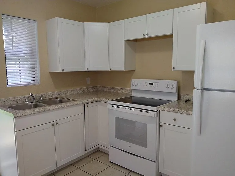 Wide view of kitchen; recently updated with new sink, cabinets, counters, stove/range, refrigerator and breakfast bar.