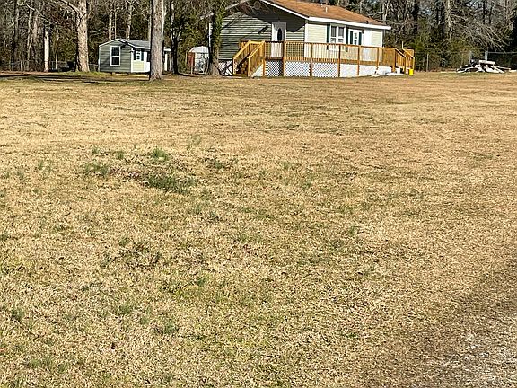 Is a photo of the COTTAGE and the office building in the rear along with part of the forested area on the property.