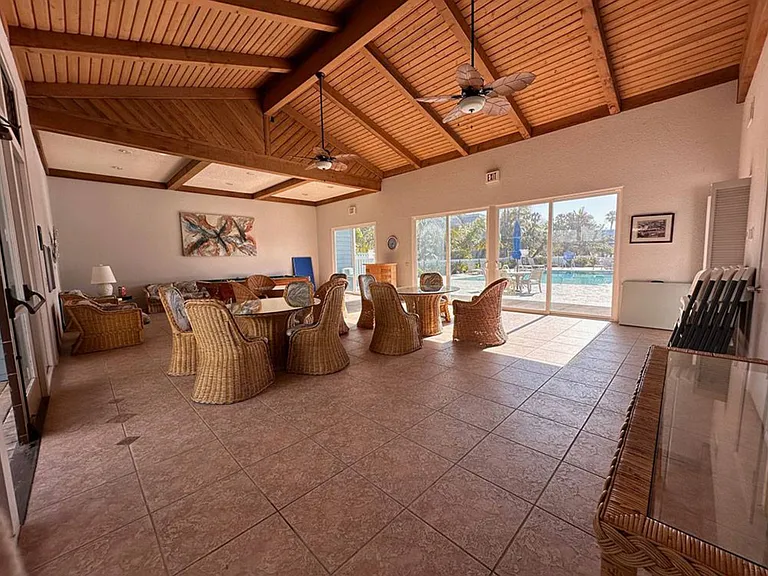 Clubhouse interior with billiards table & multiple set ups of tables/chairs for entertaining guests, families, and co-workers for entertainment, social gatherings, & special events.
