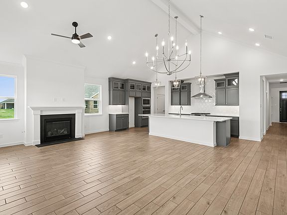 Open concept living spaces with fireplace vaulted ceiling