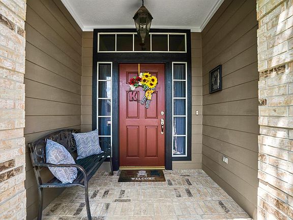 The covered porch is a symmetrical dream. The dark trimmed transom & sidelight windows frame the door beautifully allowing it to stand out. The covered porch is spacious enough to fit a bench as seen here if desired.