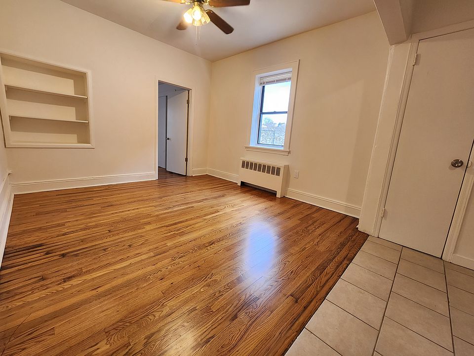Living room w/ hardwood floors & ceiling fan.