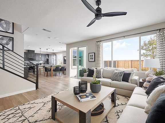 A modern and open-concept living space with a cozy seating area, a kitchen visible in the background