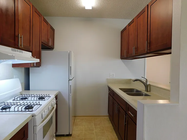 Newer kitchen cabinets and countertops. Gas range; range hood; refrigerator; disposal.