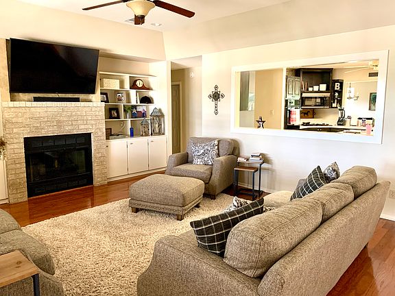 Living room with gas fireplace and lots of bookcases and cabinets.