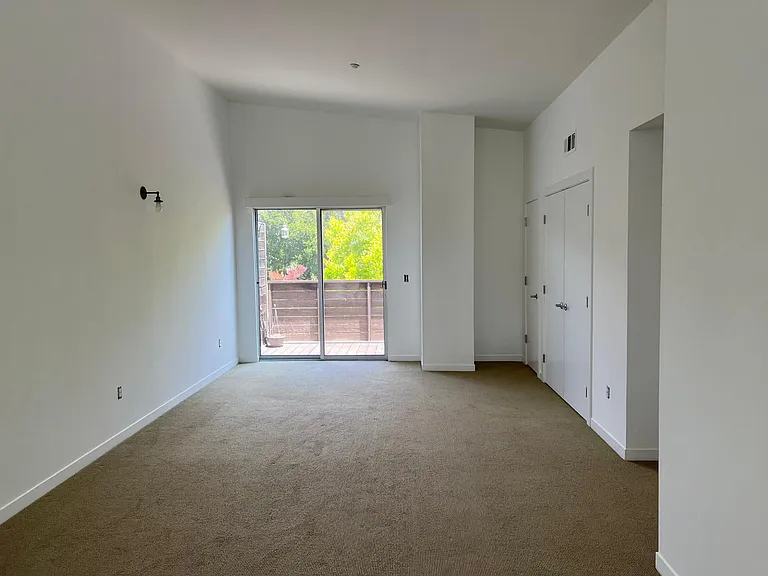 Second floor looking at the balcony at the back. Clothing closet, study alcove, and half bathroom on the right.