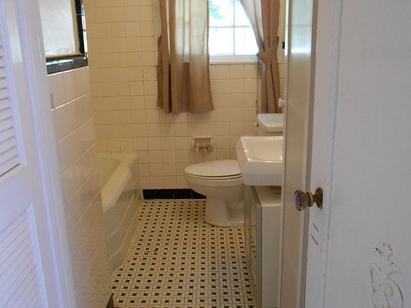 Tiled bathroom with black and white basket weave floor