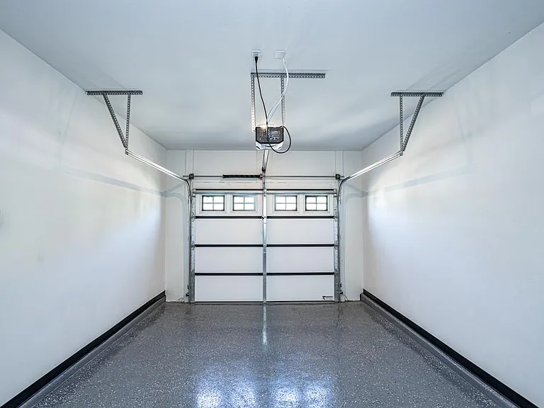 Attached 1-car garage with epoxy floors. Doubles for use as a gym, workshop or additional storage.