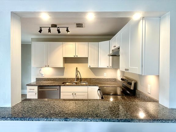 Kitchen with new granite countertops, cabinets and appliances with eat-in area for table.