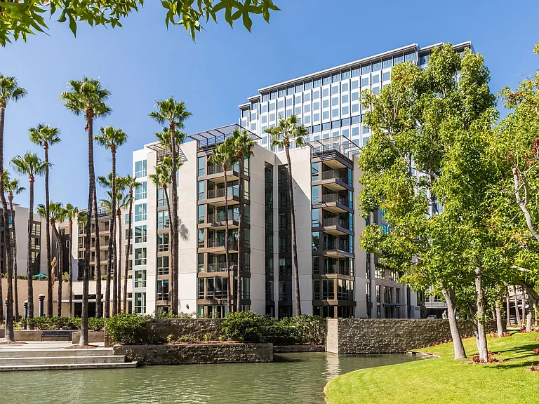 Exterior facade framed by palms and vibrant landscaping.