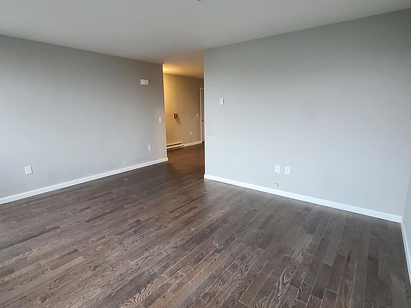 Large living room area, hardwood floors throughout, wall mounted air conditioning for the entire apartment.