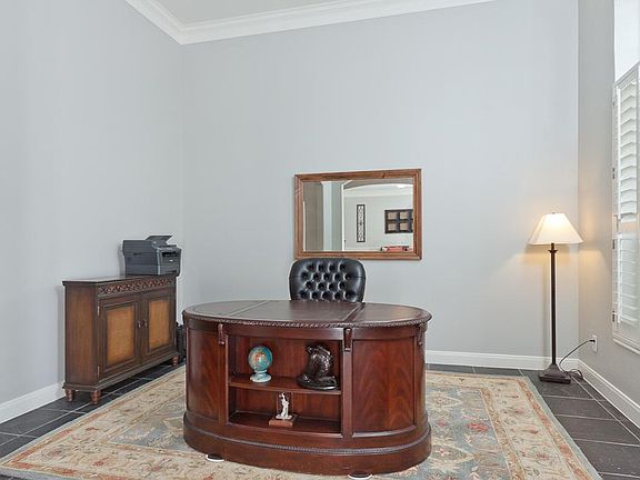 Soft neutral colors - light and bright formal living features crown moulding, slate floors and Plantation shutters