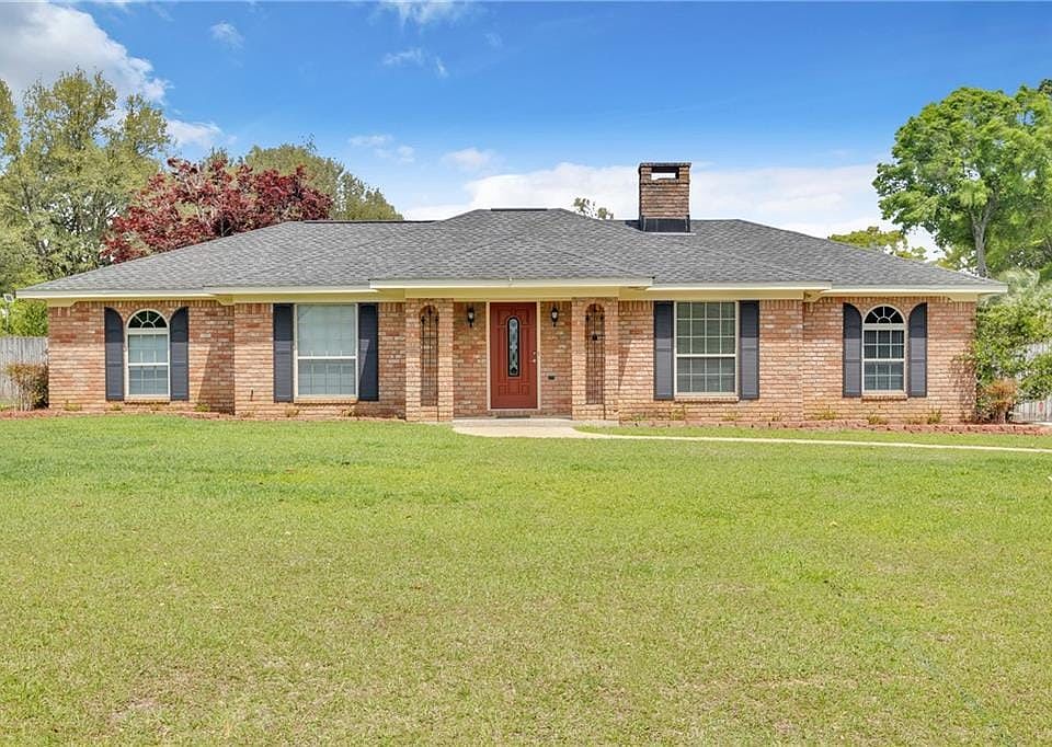 Single story home with a shingled roof, a chimney, and brick siding