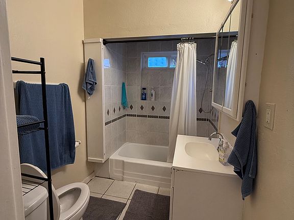 Full bathroom with storage next to the bathtub.