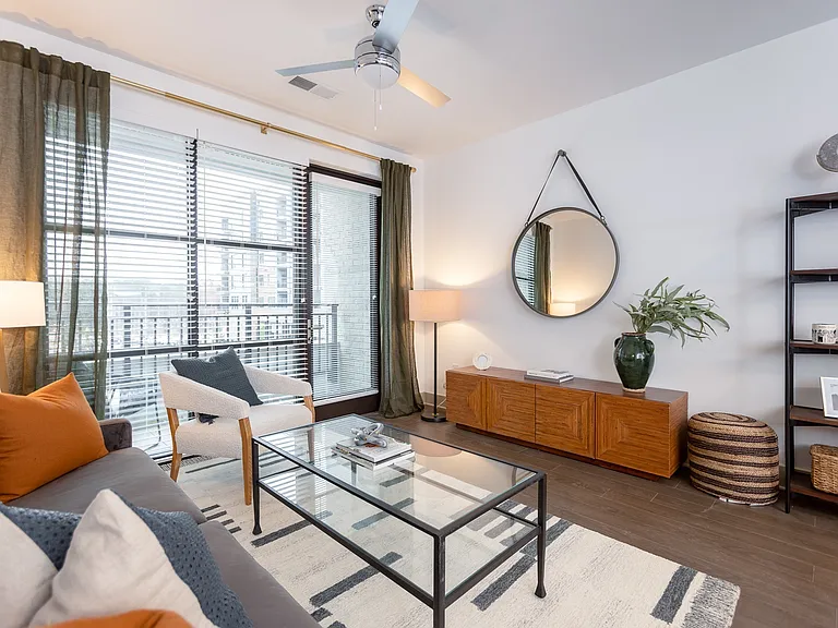 Relax in a light-filled living space that blends comfort with contemporary design and warm, earthy accents.