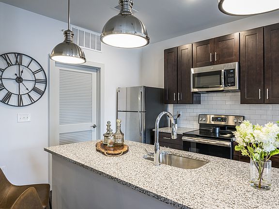 Stylish Pendant Lighting, Granite-Style Countertops, and Wood-Style Flooring