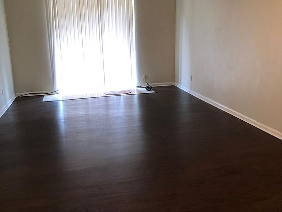 Sliding full glass doors behind blinds leads to small covered patio