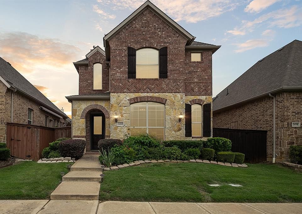French country style house featuring brick siding and stone siding